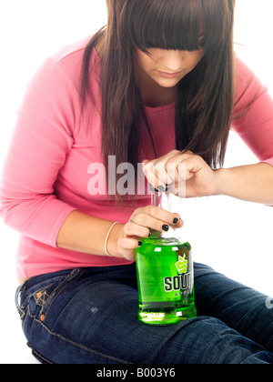 Junge Minderjährige Teenager sitzen auf dem Boden allein Erleben zugefügt Alkoholmissbrauch Alkohol trägt ein rosa Top und Blue Denim Jeans Stockfoto