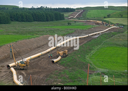 Abschnitte des großen Durchmessers Getriebe Stahl Gasleitung aufgereiht in der Landschaft vor schlossen sich zusammen und begraben Stockfoto