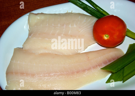 Ohne Knochen ohne Haut und ungekocht Rohteile der Heilbutt-Filet mit Tomaten grüne Zwiebel und Sellerie auf einem Teller Stockfoto