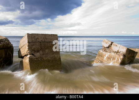 Eine Langzeitbelichtung der Wellen zwischen Strand Hindernisse. Stockfoto