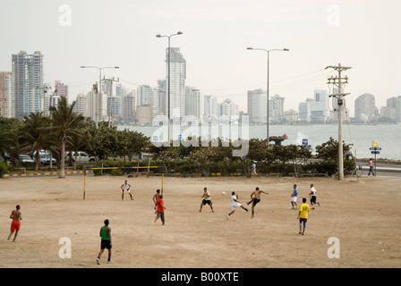 Junge Männer, die Fußball spielen auf der Uferpromenade mit Bocagrande hinter Cartagena de Indias, Kolumbien Stockfoto