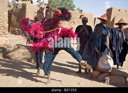 Mali, Dogonland, Tereli. Maskierte Tänzer Sprung in der Luft bei den Dogon Dorf von Tereli. Stockfoto