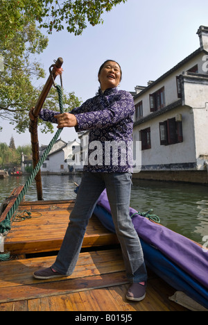 Reiseleiter singt Volkslieder, als sie Boot am Kanal von historischen Zeilen Wasser Stadt, Zhouzhuang, Provinz Jiangsu, China Stockfoto