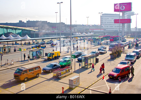 Menschen kommen und gehen auf dem Parkplatz vor dem Terminal des Flughafens Schiphol, Niederlande Stockfoto