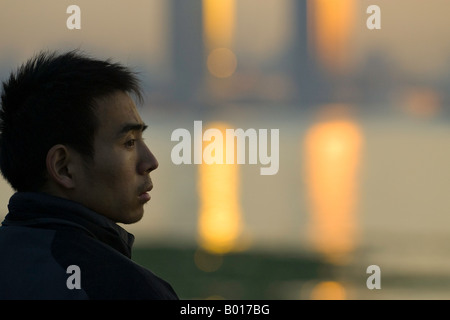 Mann reflektiert leise Uhren Sonne von Skyline und Huangpu-Fluss, der Bund, Shanghai, China Stockfoto