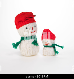 2 stricken Schneemänner mit roten Mützen und grünen Schals Stockfoto