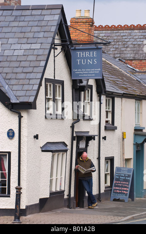 17. Jahrhundert drei Tuns Inn Hay on Wye Powys Wales UK EU aus 1600 Mann draußen lesen Zeitung Stockfoto