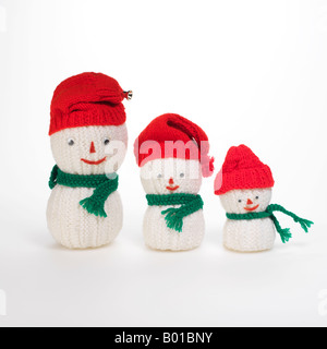 3 stricken Schneemänner Familie tragen rote Mützen und grünen Schals Stockfoto