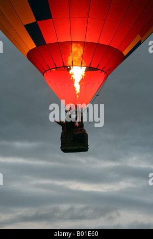 Ein Heißluftballon zieht bei Sonnenaufgang Stockfoto