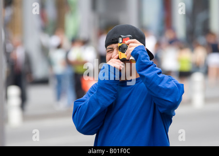 Ein Mann fängt ein Foto in Times Square in New York City, New York, USA, August 2006 Stockfoto