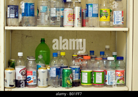 Eine Reihe von leeren Plastikflaschen und Dosen auf einem Regal. Stockfoto