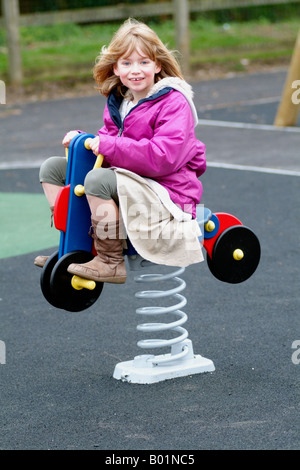 Kinderspielplatz mit Soft-Play Sicherheit Oberfläche kleine Mädchen spielen auf Frühling Rocker Ausrüstung Stockfoto