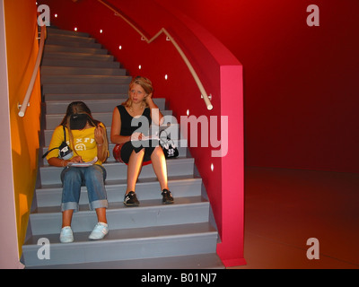 Innere des Groninger Museum Groningen Niederlande mit zwei Studenten, die Zuordnung beim Sitzen auf Schritte tun Stockfoto