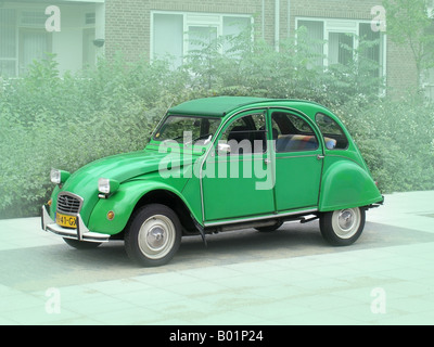 grüne Citroen Deux Chevaux Straßenrand vor grünem Hintergrund Stockfoto