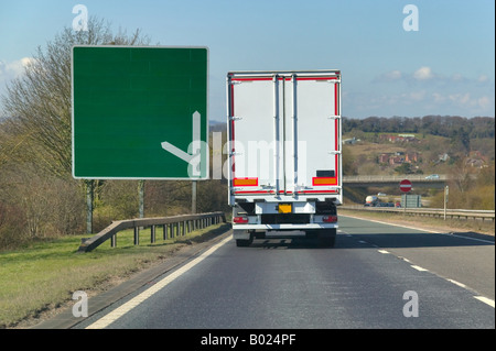 Weißen LKW LKW vorbei ein Wegweiser auf eine zweispurige leeren Sie Ihren eigenen Text hinzufügen Stockfoto