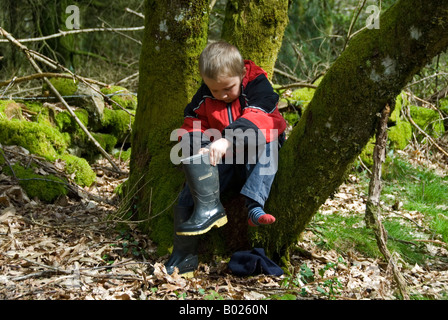 Stock Foto eines jungen, der immer einen Steins aus seinen Stiefeln auf ein Land zu Fuß Stockfoto