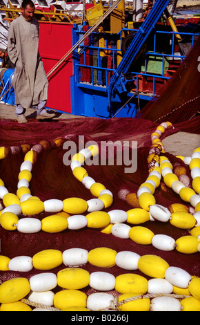 Farbenfrohe Fischernetze und Bojen im Küstenhafen Larache, Marokko, mit maritimen Aktivitäten und traditioneller Angelausrüstung. Stockfoto