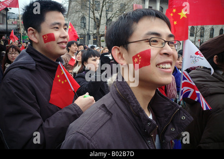 Zwei junge chinesische Studenten feiern die Prozession der Olympischen Fackel durch London auf Trafalgare Platz Stockfoto