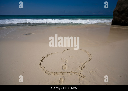 Herz im Sand mit seinen und ihren Fußspuren auf den Seychellen Stockfoto