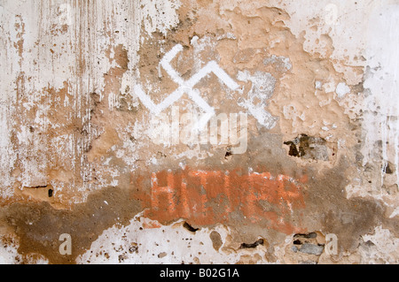 Faschistischen Graffitti Hakenkreuz und Wort Hitler durchgestrichen auf alten Mauer Stockfoto