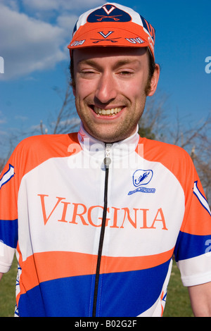 Porträt einer Hochschule im Alter von jungen männlichen Radfahrer im Team uniform mit Orange, blauen und weißen Farben. Stockfoto