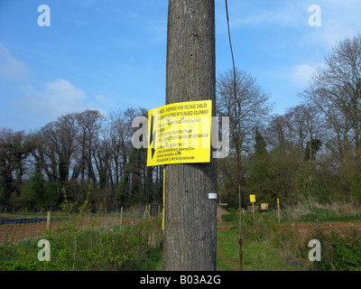 Eine Schild Warnung der obenliegenden Gefahr ist mehrsprachig, meist osteuropäische, auf Ackerland bei Milford, Surrey, UK. Stockfoto