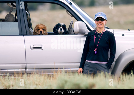 Aktive Frau stand vor SUV mit 2 Cocker Spaniel Stockfoto