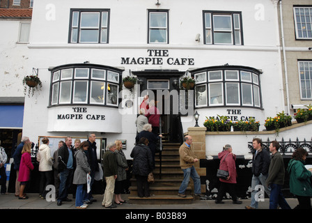 Die regulären Warteschlange vor dem berühmten Fish and Chips-Restaurant The Magpie Cafe in Whitby North Yorkshire. Stockfoto