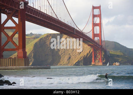 eine Surfer reitet auf eine Welle in der Nähe der Golden Gate Bridge in San Francisco, Kalifornien Stockfoto