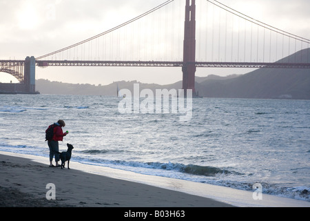 eine Frau und ihr Hund am Strand von Crissy Field in San Francisco, Kalifornien Stockfoto