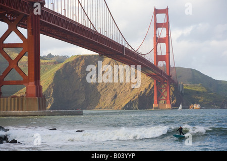 eine Surfer reitet auf eine Welle in der Nähe der Golden Gate Bridge in San Francisco, Kalifornien Stockfoto