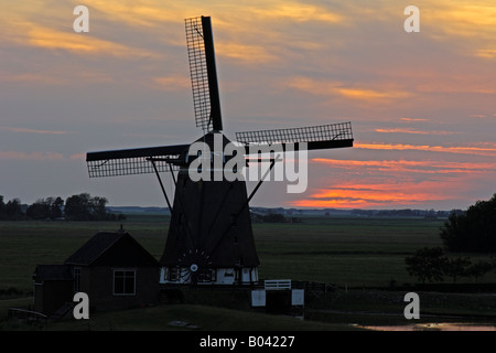 holländische Windmühle in roten Sonnenuntergang Insel Texel Niederlande Stockfoto