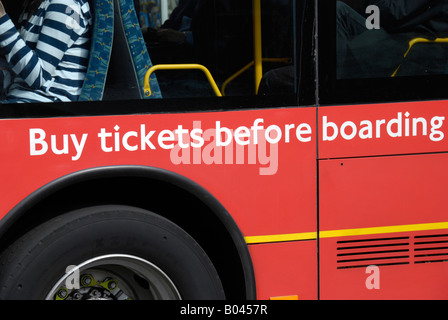 Melden Sie sich auf der roten Londoner Bus bitten Passagiere Tickets vor dem Einsteigen kaufen Stockfoto