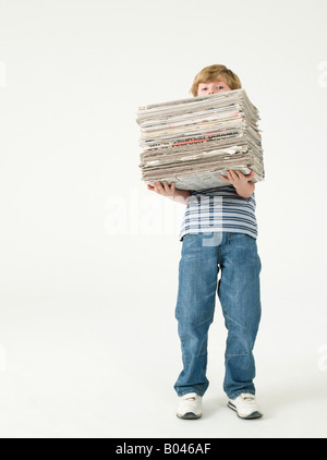 Junge hält einen Stapel Zeitungen Stockfoto