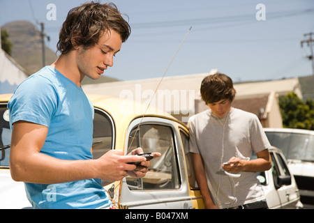 Jungs im Teenageralter anhören von MP3-Player und Video-Spiel Stockfoto