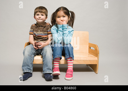 Ein Junge und ein Mädchen saß auf einer Bank Stockfoto