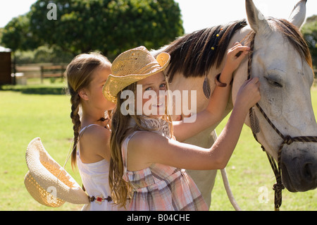 Zwei Mädchen streicheln ein Pferd Stockfoto