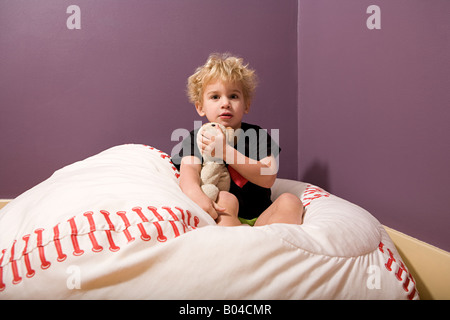 Junge im Bett mit Teddybär Stockfoto