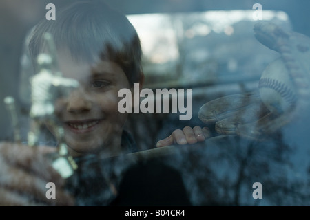 Junge mit Trophäe durch Fenster Stockfoto