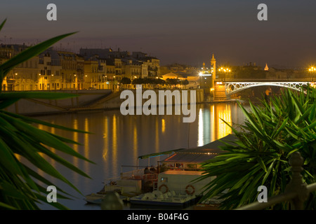 Puente de Isabel II (Brücke) über den Rio Guadalquivir (Fluss), Stadtteil Triana in der Abenddämmerung, Stadt Sevilla Stockfoto