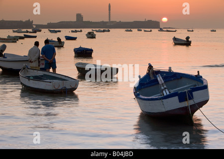 Kleine Fischerboote verankert am Playa De La Caleta bei Sonnenuntergang in der Stadt Cadiz, Provinz Cádiz, Costa De La Luz, Andalusien Stockfoto