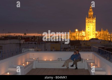 Zu zweit auf der Terrasse am Banos Arabes-Aire de Sevilla mit La Giralda und Sevilla Kathedrale im Hintergrund in der Abenddämmerung Stockfoto