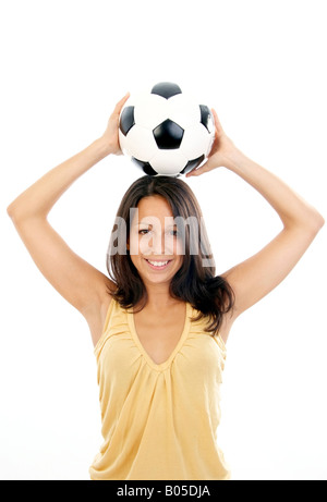junge nette Frau mit Fußball, mit dem Ball über den Kopf Stockfoto