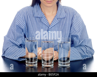 Frau im Schlafanzug mit Gläser Wasser Model Released Stockfoto