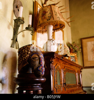 Ecke eines Raumes mit tribal Mask und alte altmodische Lampe auf Konsole Stockfoto