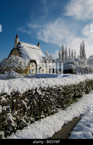 Eine strohgedeckte Hütte auf einem verschneiten Sonnentag, Warwickshire, England, UK. Stockfoto