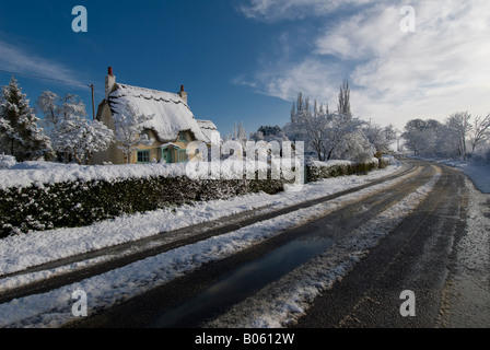 Eine strohgedeckte Hütte auf einem verschneiten Sonnentag, Warwickshire, England, UK. Stockfoto