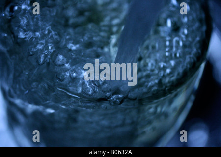 Nahaufnahme von Wasser in ein Glas gegossen wird. Stockfoto