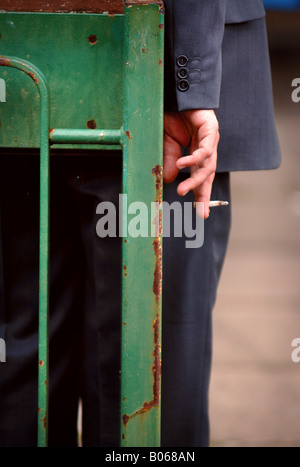 EIN BÜROANGESTELLTER NIMMT EINE ZIGARETTENPAUSE IN EINER URBANEN STANDORT UK Stockfoto