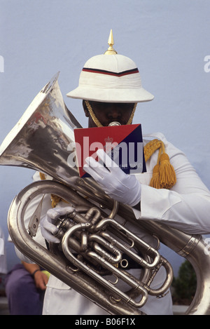 Intelligenter Bandsman des Royal Bermuda Regiment, in feinem Helm und weißer Uniform. Er besitzt ein hochglanzpoliertes Tuba-Instrument und liest seine Musik Stockfoto